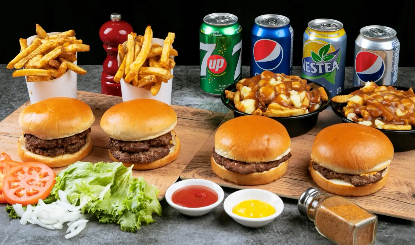 A Sam's Grill family pack of burgers, fries and poutine laid out on a table